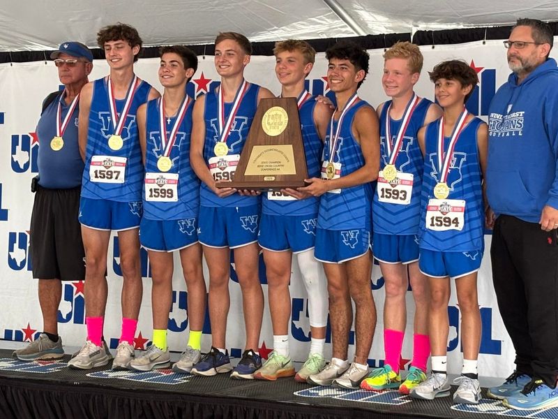 The Windthorst boys cross country team poses with their gold medals and first-place trophy after winning the Class 2A race at the UIL State Cross Country Championships on Nov. 1, 2025 at Old Settlers Park in Round Rock.