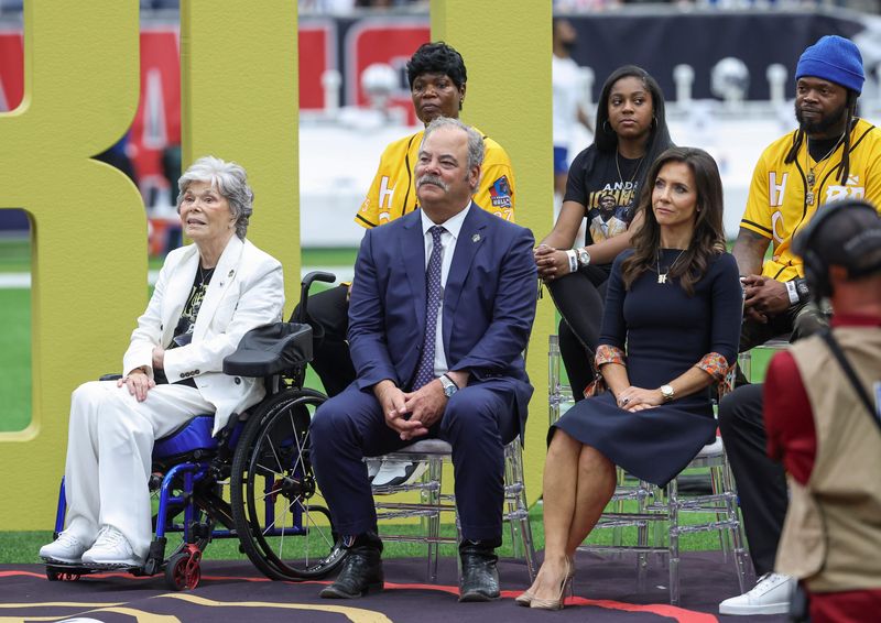 Oct 27, 2024; Houston, Texas, USA; Houston Texans co-founder and former owner Janice McNair (left) sits with Texans chief executive officer Cal McNair and wife Hannah McNair in front of family members of Texans former player Andre Johnson (not pictured) during a ceremony at halftime of the game against the Indianapolis Colts at NRG Stadium. Mandatory Credit: Troy Taormina-Imagn Images