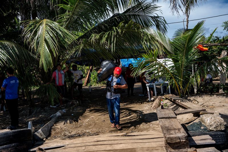 Jose Iguaran, a 46-year-old migrant from Venezuela, carries his belongings on Aug. 18, 2025, as he heads to a fishing boat bound for Colombia from Palenque, Panama. Iguaran, a member of the Indigenous Guahibo people, was trying to return to his home country after giving up on his goal of seeking asylum in the U.S. to provide for his family amid economic and political turmoil in Venezuela.