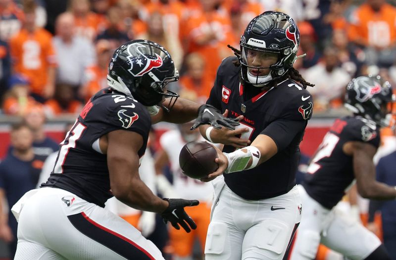 Nov 2, 2025; Houston, Texas, USA; Houston Texans quarterback C.J. Stroud (7) hands off to running back Nick Chubb (21) during the first half against the Denver Broncos at NRG Stadium. Mandatory Credit: Thomas Shea-Imagn Images