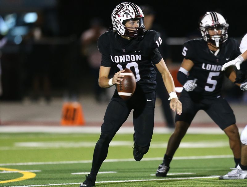 London quarterback Alex Manning looks for an open receiver after breaking the pocket during a football game against Orange Grove on Thursday, Nov. 6, 2025 at Pirate Stadium.