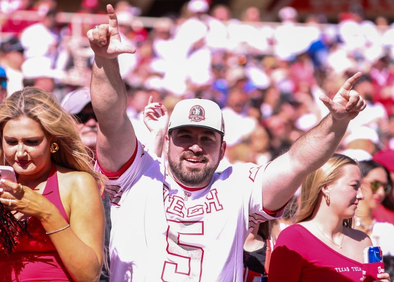 A Texas Tech fan holds the Guns Up handle gesture during a Big 12 Conference football game, Saturday, Nov. 8, 2025, at Jones AT&T Stadium.