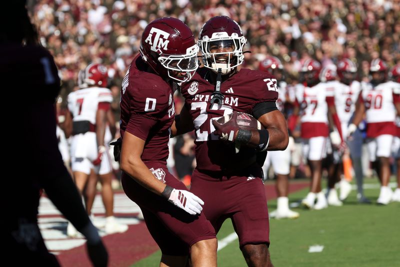 Nov 15, 2025; College Station, Texas, USA; Texas A&M Aggies running back Ej Smith (22) celebrates with wide receiver Izaiah Williams (0) after scoring a touchdown during the fourth quarter against the South Carolina Gamecocks at Kyle Field. Mandatory Credit: Troy Taormina-Imagn Images