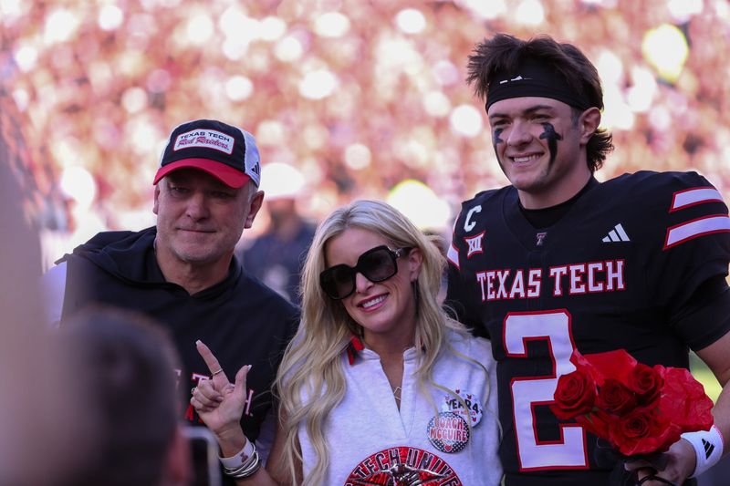 Behren Morton stands with Joey and Debbie McGuire during Texas Tech's senior day ceremony before a Big 12 Conference football game, Saturday, Nov. 15, 2025, at Jones AT&T Stadium.
