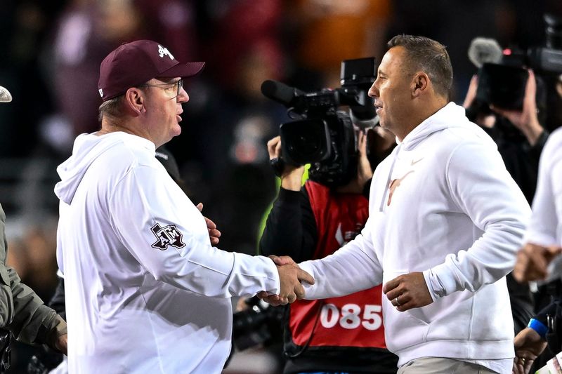 Nov 30, 2024; College Station, Texas, USA; Texas A&M Aggies head coach Mike Elko, left, shakes hands with Texas Longhorns head coach Steve Sarkisian after the game. The Longhorns defeated the Aggies 17-7. at Kyle Field. Mandatory Credit: Maria Lysaker-Imagn Images