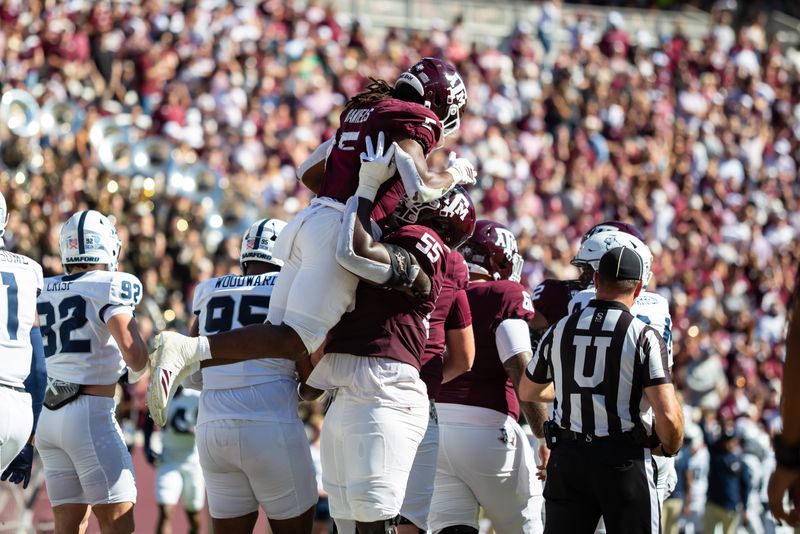 Nov 22, 2025; College Station, Texas, USA; Texas A&M Aggies running back Amari Daniels (5) is lift into the air by offensive lineman Ar'maj Reed-Adams (55) in the first half of a game against the Samford Bulldogs at Kyle Field. Mandatory Credit: Joseph Buvid-Imagn Images