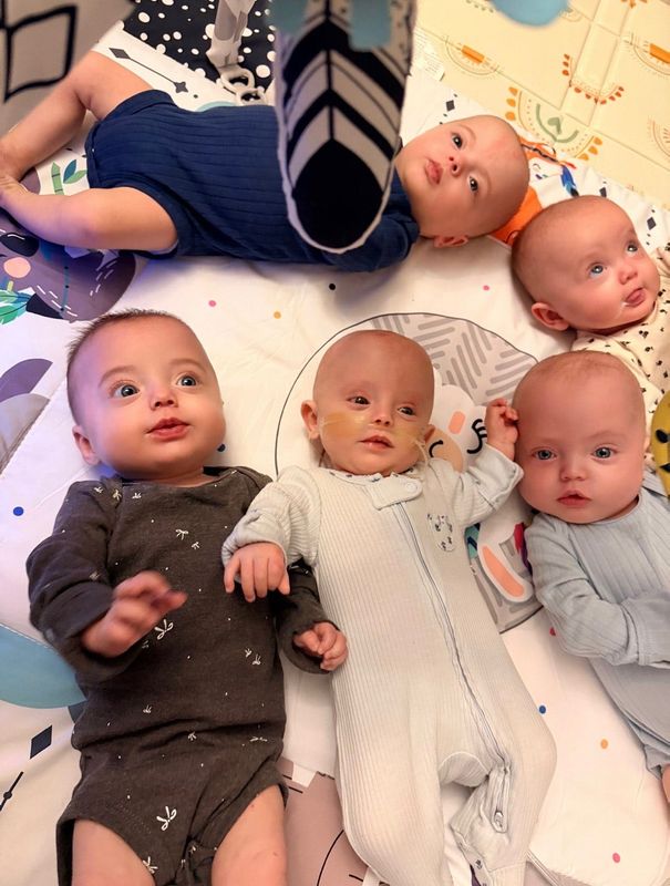 New mom Theresa Troia is happy to have her quintuplets together at home at last. Left to right: Isabella (gray onesie) then Viviana, Joseph, Kyla and on top is Jaxon.
