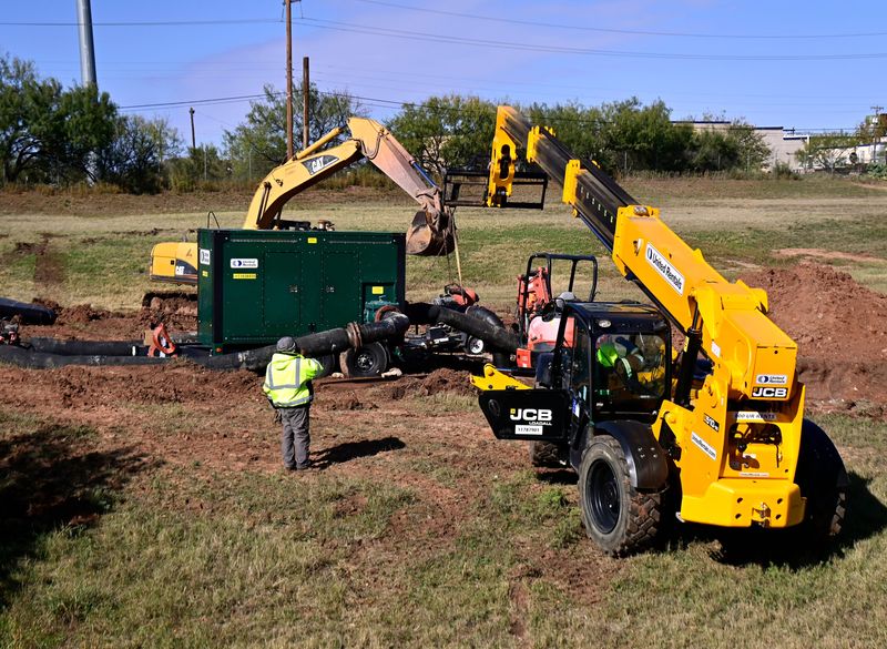 Crews work as they repair the damage from a sanitary sewer overflow in Cedar Creek Wednesday. Abilene officials said in a release there was no threat to the city’s drinking water.