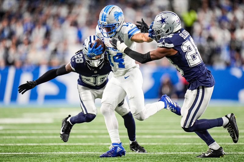 Dec 4, 2025; Detroit, Michigan, USA; Detroit Lions wide receiver Amon-Ra St. Brown (14) makes a catch against Dallas Cowboys safety Malik Hooker (28) and cornerback DaRon Bland (26) during the first half at Ford Field. Mandatory Credit: Junfu Han-USA TODAY Network via Imagn Images