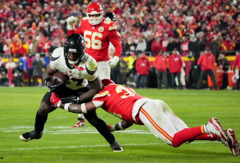 Dec 7, 2025; Kansas City, Missouri, USA; Houston Texans running back Woody Marks (27) runs the ball against Kansas City Chiefs linebacker Nick Bolton (32) during the second quarter at GEHA Field at Arrowhead Stadium. Mandatory Credit: Denny Medley-Imagn Images