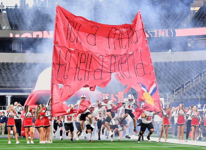 Muenster breaks through a sign as they run out onto the field during the 2025 UIL 2A DII State Championship game against Shiner at AT&T Stadium in Arlington, on Thursday, Dec. 18, 2025.