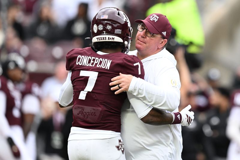 Dec 20, 2025; College Station, TX, USA; Texas A&M Aggies head coach Mike Elko hugs Texas A&M Aggies wide receiver KC Concepcion (7) prior to the game against the Miami Hurricanes during the first round of the CFP National Playoff at Kyle Field. Mandatory Credit: Maria Lysaker-Imagn Images