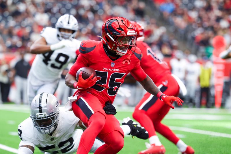 Dec 21, 2025; Houston, Texas, USA; Houston Texans running back Jawhar Jordan (26) rushes against Las Vegas Raiders linebacker Elandon Roberts (52) during the first quarter at NRG Stadium. Mandatory Credit: Troy Taormina-Imagn Images