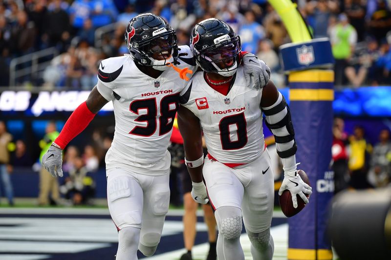 Dec 27, 2025; Inglewood, California, USA; Houston Texans linebacker Azeez al-Shaair (0) reacts with safety K'Von Wallace (38) after making an interception against the Los Angeles Chargers during the first half at SoFi Stadium. Mandatory Credit: Gary A. Vasquez-Imagn Images