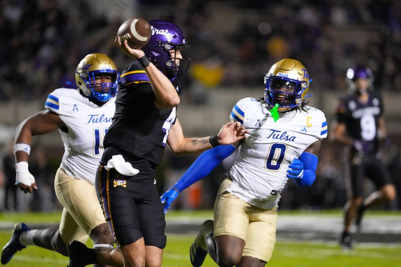 Oct 16, 2025; Greenville, North Carolina, USA; East Carolina Pirates quarterback Katin Houser (4) throws the ball against Tulsa Golden Hurricane linebacker Ray Coney (0) during the first half at Dowdy-Ficklen Stadium. Mandatory Credit: James Guillory-Imagn Images
