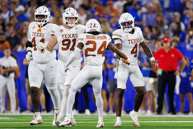 Oct 18, 2025; Lexington, Kentucky, USA; Texas Longhorns defensive back Warren Roberson (24) fives defensive back Jelani McDonald (4) during the second quarter against the Kentucky Wildcats at Kroger Field. Mandatory Credit: Jordan Prather-Imagn Images