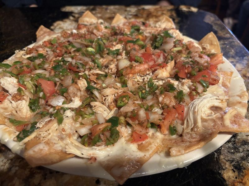 The Killer Nachos with chicken nachos at Track One are a shareable appetizer with layers of refried beans, shredded tender chicken breast, melted white cheddar cheese and flavorful pico de gallo. $13.8 including chicken.