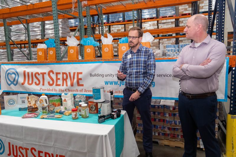 Zack Wilson, executive director of High Plains Food Bank, speaks Thursday at the food bank’s warehouse in Amarillo as Brock Blaser, stake president, Church of Jesus Christ of Latter-day Saints, looks on during the arrival of a 40,000-pound food donation.