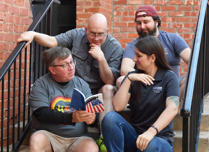 Chance Harmon (top left), the artistic and technical director at Backdoor Theatre, Martin Ballard (top right), the operations and production assistant at Backdoor Theatre, Mark Dudley (bottom left), the box office manager at Backdoor Theatre, and Jessica Wood (bottom right), the executive managing director at Backdoor Theatre, look over a script on Friday, Feb. 3, 2026, outside the Dinner Stage entrance, located at 501 Indiana Ave., in Wichita Falls. The theater will have a celebration on April 10 in honor of its 50th anniversary.