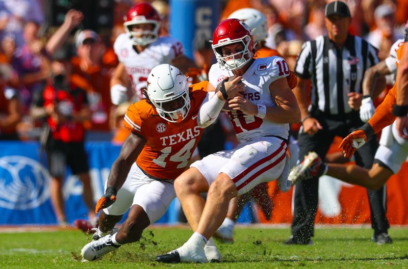 Oct 11, 2025; Dallas, Texas, USA; Texas Longhorns linebacker Brad Spence (14) looks to tackle Oklahoma Sooners quarterback John Mateer (10) during the first half at the Cotton Bowl. Mandatory Credit: Kevin Jairaj-Imagn Images