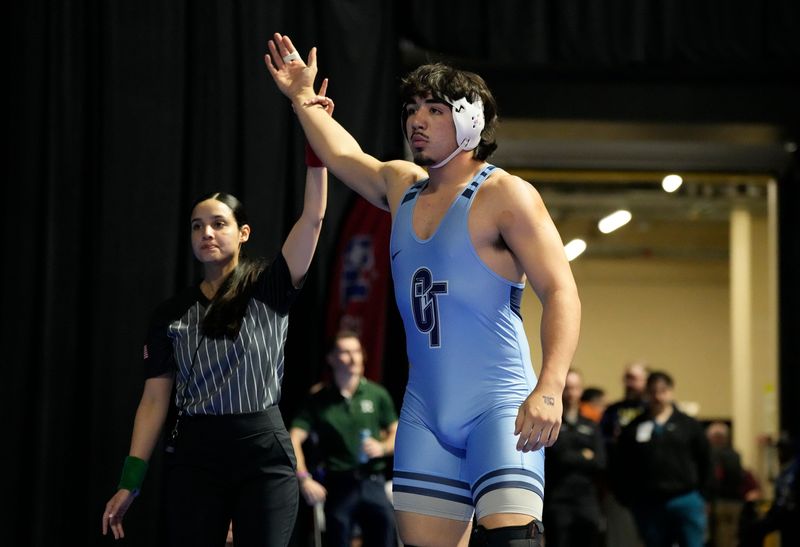 Corpus Christi Carroll’s Roman Nino celebrates his victory against Frisco Reedy’s Charlie Roy in the 5A 215 weight class during the UIL State Wrestling Championship at Berry Center Arena, Friday, Feb. 13, 2026, in Houston.