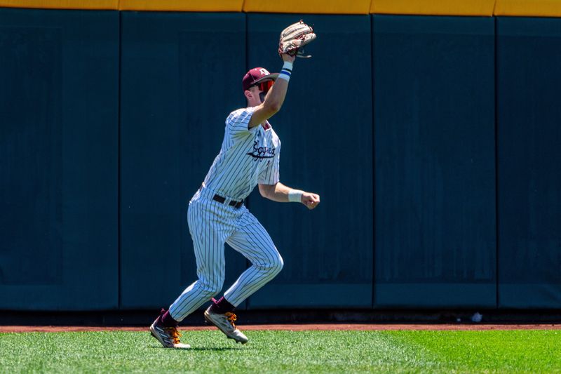 Jun 23, 2024; Omaha, NE, USA; Texas A&M Aggies left fielder Caden Sorrell (13) makes a catch against the Tennessee Volunteers during the first inning at Charles Schwab Field Omaha.