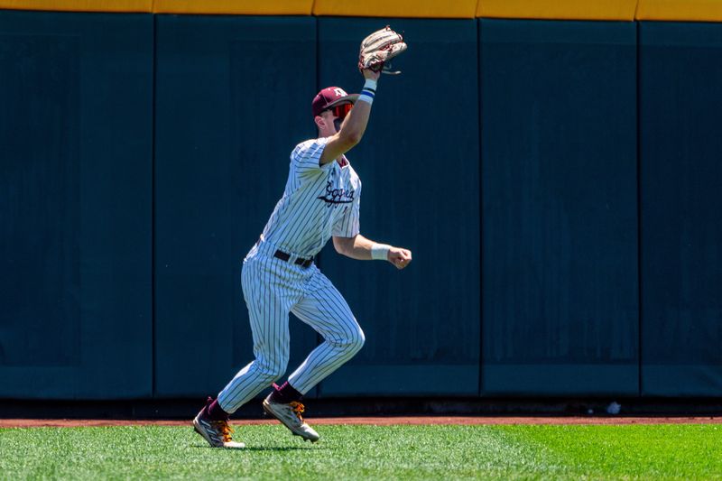 Jun 23, 2024; Omaha, NE, USA; Texas A&M Aggies left fielder Caden Sorrell (13) makes a catch against the Tennessee Volunteers during the first inning at Charles Schwab Field Omaha.