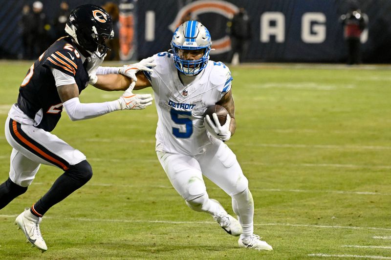 Jan 4, 2026; Chicago, Illinois, USA; Detroit Lions running back David Montgomery (5) runs with the ball against Chicago Bears cornerback Nahshon Wright (26) during the second half at Soldier Field. Mandatory Credit: Matt Marton-Imagn Images