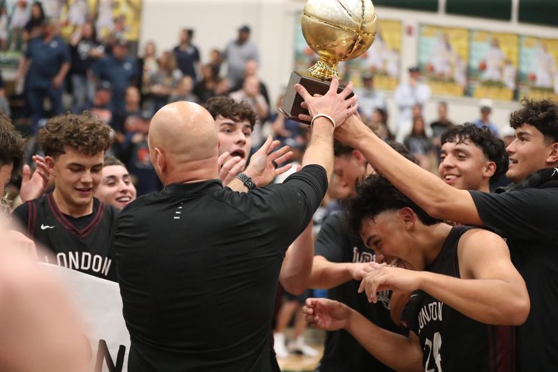 London boys basketball coach Sean Armstrong hands the Region IV-3A championship trophy to the Pirates following Thursday's 68-61 overtime win against Goliad at Rockport-Fulton High School on March 5, 2026.