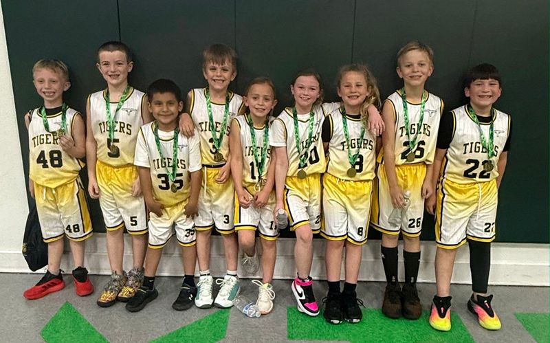 Cerys Fuller, No. 8, poses with the McLean youth basketball team after they won the Shamrock tournament in February.