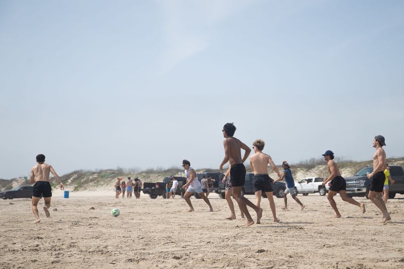 College students from Austin and Houston play soccer at Port Aransas Beach on March 7.