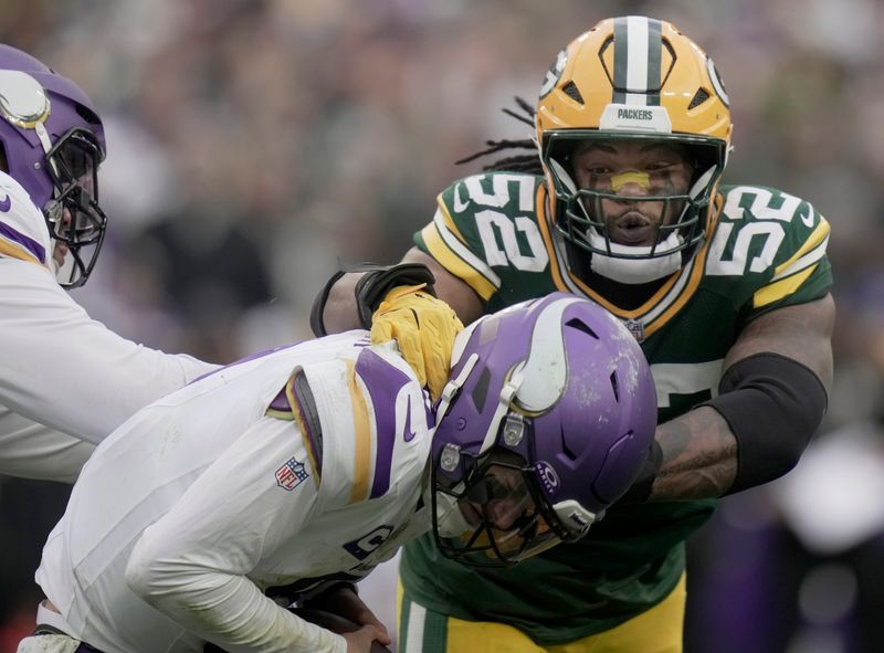 Minnesota Vikings' J.J. McCarthy (9) evades a sack by Green Bay Packers defensive end Rashan Gary (52) during the fourth quarter of their game Sunday, November 23, 2025 at Lambeau Field in Green Bay, Wisconsin. The Green Bay Packers beat the Minnesota Vikings 23-6.
