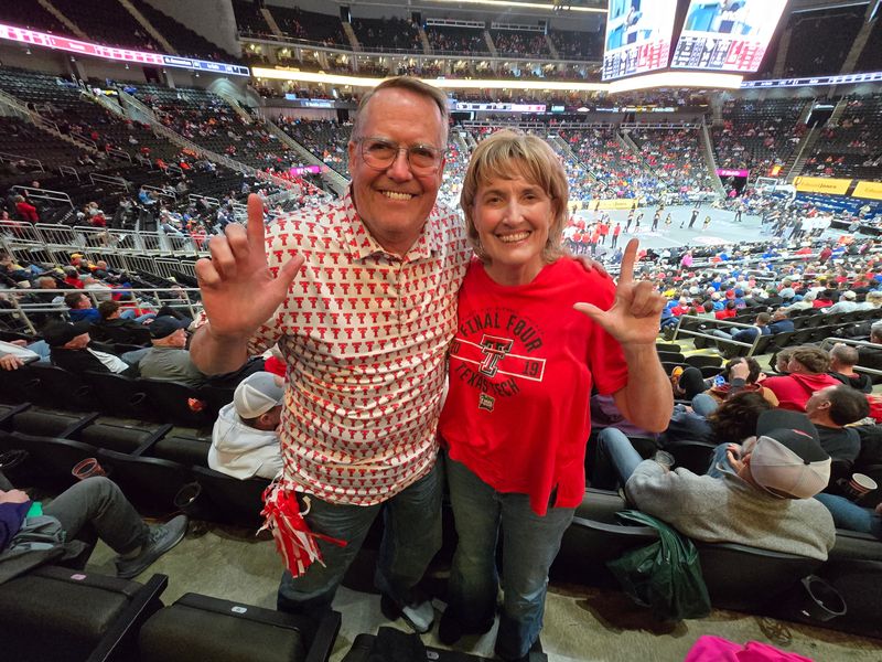 Texas Tech fans Tony and Phyllis Hopp hold the Guns Up hand signal while attending the Big 12 Tournament, Wednesday, March 11, 2026, in T-Mobile Center in Kansas city.