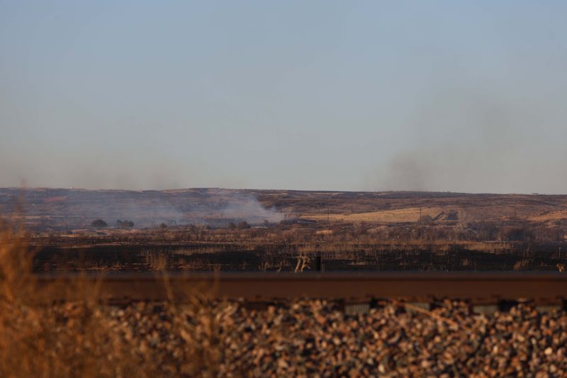 Smoke surrounded by charred land could be seen along Highway 1061 Wednesday evening from the Yellow Fire near Boys Ranch.
