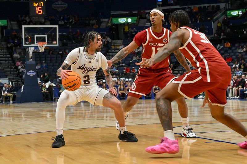 Mar 12, 2026; Nashville, TN, USA; Texas A&M Aggies guard Pop Isaacs (2) Texas A&M Aggies while Oklahoma Sooners guard Jadon Jones (12) and forward Derrion Reid (35) guard him during the first half at Bridgestone Arena. Mandatory Credit: Steve Roberts-Imagn Images