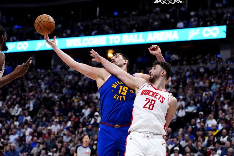 Mar 11, 2026; Denver, Colorado, USA; Denver Nuggets center Nikola Jokic (15) and Houston Rockets center Alperen Sengun (28) reach for a loose ball in the second half at Ball Arena. Mandatory Credit: Ron Chenoy-Imagn Images
