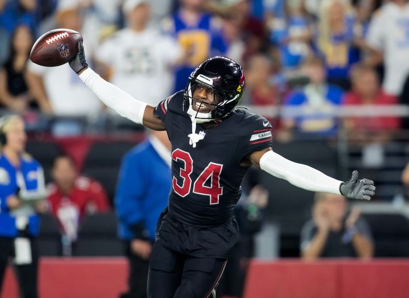 Oct 21, 2024; Glendale, Arizona, USA; Arizona Cardinals safety Jalen Thompson (34) celebrates after recovering a fumble from the Los Angeles Chargers in the first half at State Farm Stadium. Mandatory Credit: Mark J. Rebilas-Imagn Images