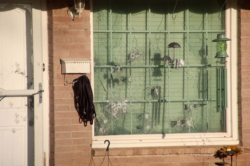 Bullet holes and cracked glass are seen March 24 in the window and door at a residence in the 2900 Block of South Dallas of Amarillo, where a shooting took place early March 22. Three family members were injured inside the residence, and two people who rushed to the scene after hearing gunfire were killed.