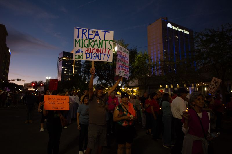 A man holds up a sign that reads "treat migrants with humility and dignity" during a march in favor of immigrants organized by the Diocese of El Paso on March 24, 2026.