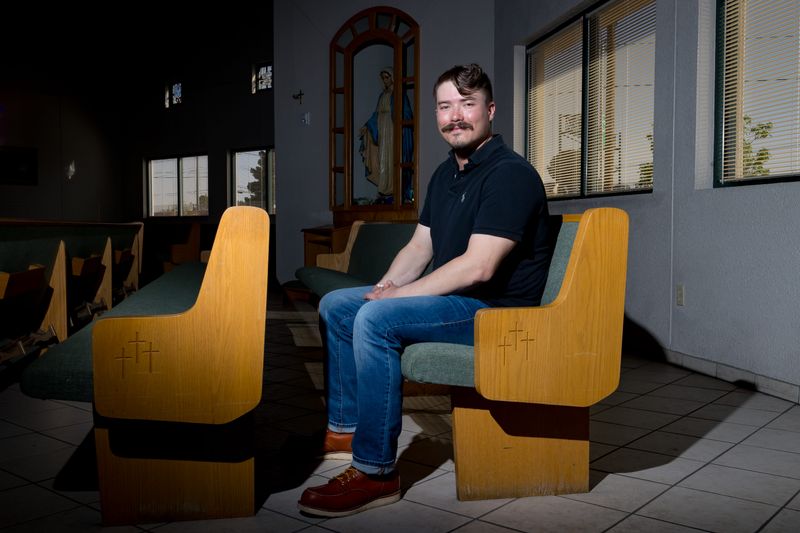Mason Thompson sits inside Most Holy Trinity Catholic Church on Friday, March 27, 2026, in El Paso, Texas. After a two-year journey of faith, Thompson, a former serviceman, will be baptized into the Catholic Church this Easter weekend.