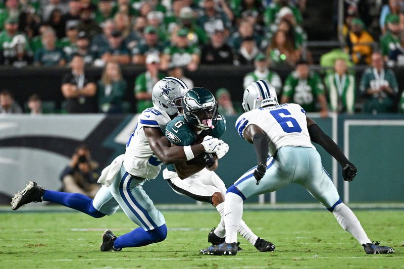 Sep 4, 2025; Philadelphia, Pennsylvania, USA; Philadelphia Eagles wide receiver DeVonta Smith (6) is tackled by Dallas Cowboys linebacker Kenneth Murray Jr. (59) and safety Donovan Wilson (6) during the second quarter of the game at Lincoln Financial Field. Mandatory Credit: Eric Hartline-Imagn Images