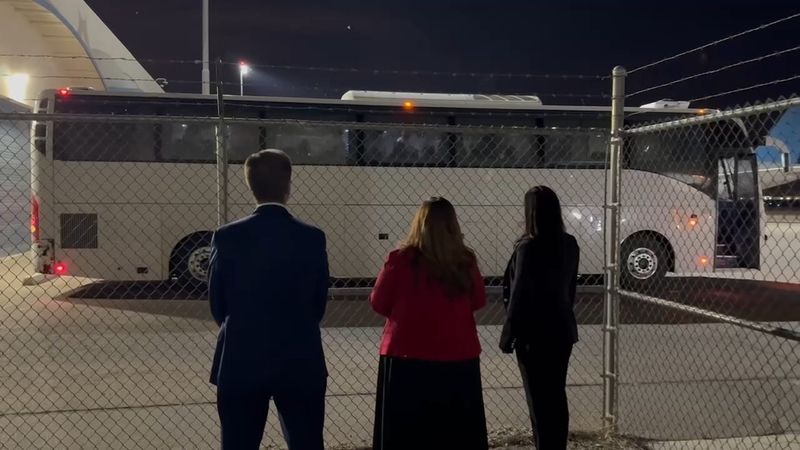 U.S. Reps. Greg Stanton, Adelita Grijalva and Yassamin Ansari observe a charter bus carrying who they believe are people in ICE custody outside the Arizona Removal Operations Coordination Center at Mesa Gateway Airport on April 9, 2026.