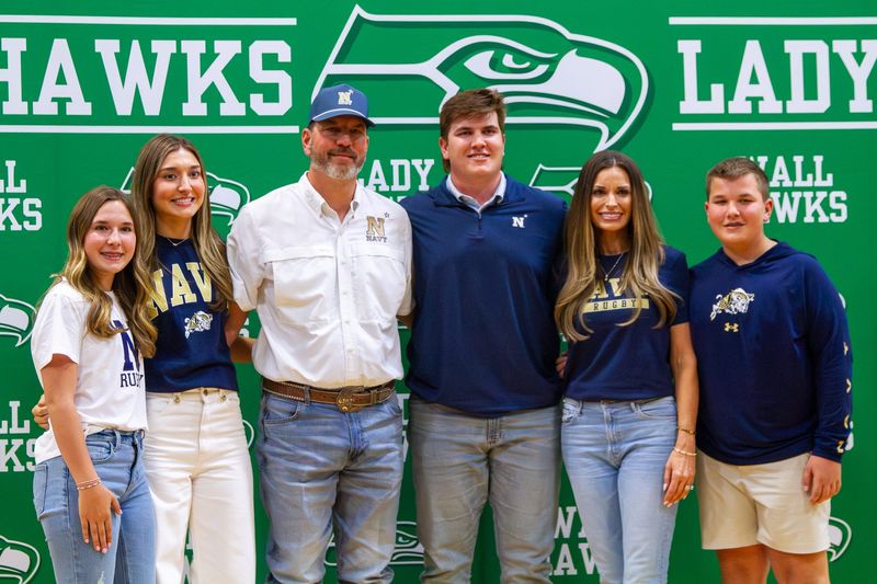 Baine Jenschke (middle-right) poses for a picture with his family after signing an academic scholarship to play Rugby at the U.S. Naval Academy at Wall High School on Tuesday, April 7, 2026.