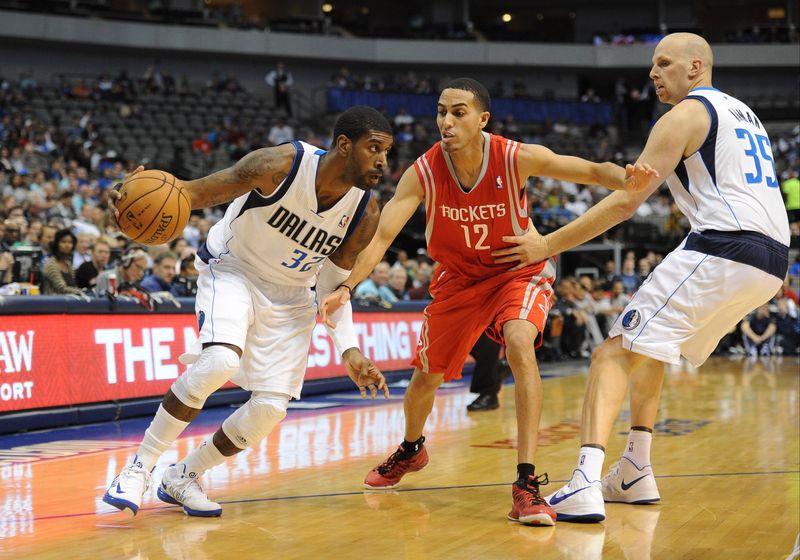 Oct 15, 2012; Dallas, TX, USA; Dallas Mavericks guard O.J. Mayo (32) dribbles the ball past Houston Rockets guard Kevin Martin (12) and Mavericks center Chris Kaman (35) during the first quarter at the American Airlines Center. Mandatory Credit: Jerome Miron-USA TODAY Sports