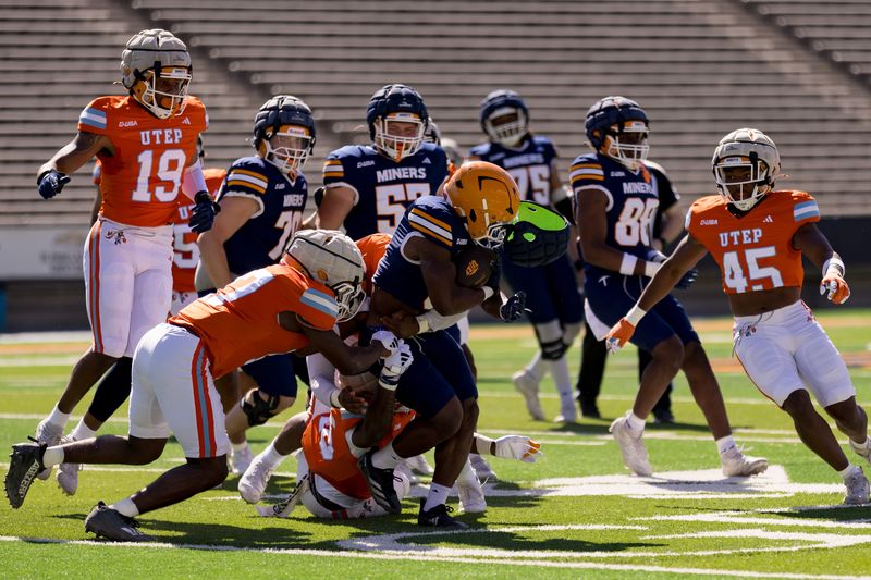Elijah McCoy runs the ball as defenders attempt to bring him down during the UTEP Spring Game at the Sun Bowl in El Paso on Saturday, April 18, 2026.