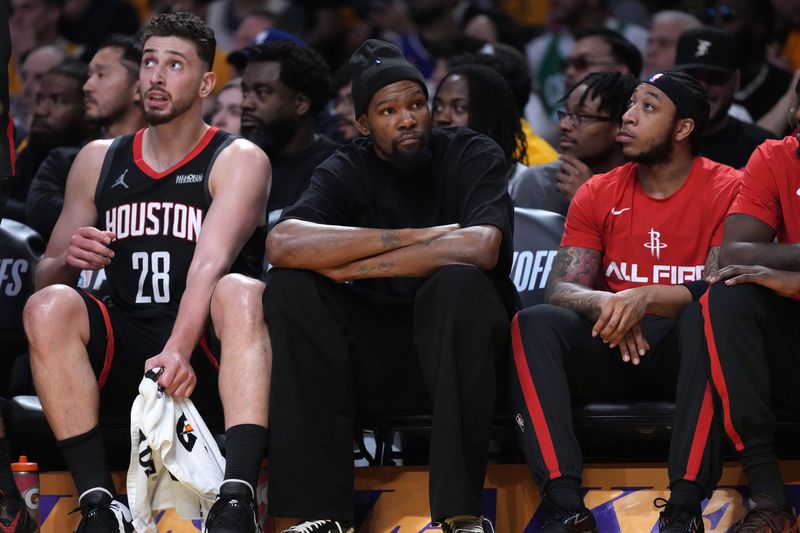 Apr 18, 2026; Los Angeles, California, USA; Houston Rockets center Alperen Sengun (28) and forward Kevin Durant (center) watch during the first half against the Los Angeles Lakers during game one of the first round of the 2026 NBA Playoffs at Crypto.com Arena. Mandatory Credit: Kirby Lee-Imagn Images