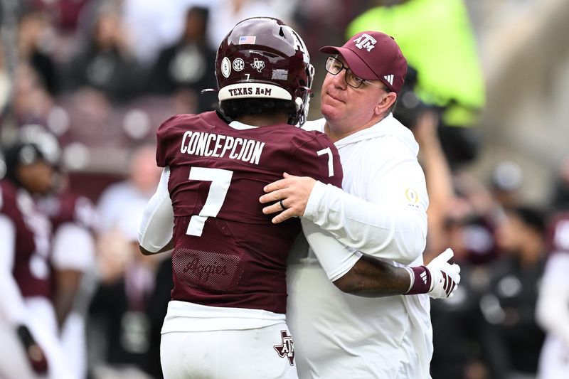 Dec 20, 2025; College Station, TX, USA; Texas A&M Aggies head coach Mike Elko hugs Texas A&M Aggies wide receiver KC Concepcion (7) prior to the game against the Miami Hurricanes during the first round of the CFP National Playoff at Kyle Field. Mandatory Credit: Maria Lysaker-Imagn Images