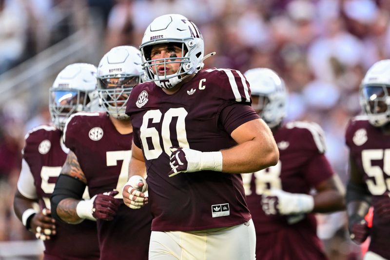 Oct 11, 2025; College Station, Texas, USA; Texas A&M Aggies offensive lineman Trey Zuhn III (60) and the offense runs onto the field in the first half against the Florida Gators at Kyle Field. Mandatory Credit: Maria Lysaker-Imagn Images