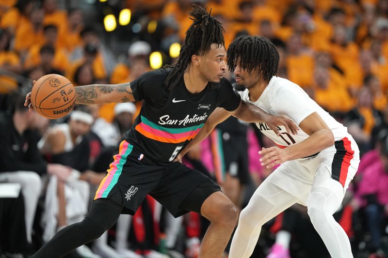 San Antonio, Texas, USA; San Antonio Spurs guard Stephon Castle (5) looks to pass the ball while defended by Portland Trail Blazers guard Shaedon Sharpe (17) during game one of the first round of the 2026 NBA Playoffs at Frost Bank Center.