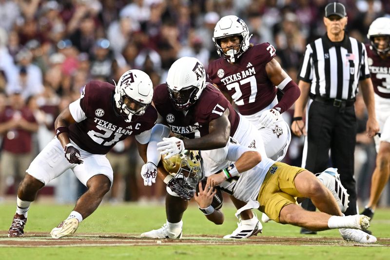 Aug 31, 2024; College Station, Texas, USA; Texas A&M Aggies linebacker Taurean York (21) and defensive lineman Albert Regis (17) tackle Notre Dame Fighting Irish quarterback Riley Leonard (13) during the second quarter at Kyle Field. Mandatory Credit: Maria Lysaker-USA TODAY Sports